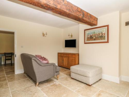 a living room with a chair and a tv at Copmanthorpe Hall in York