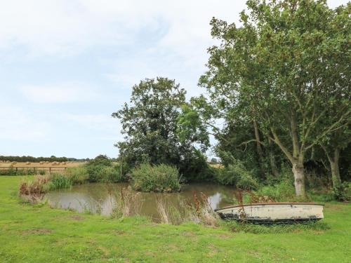 a boat sitting in the grass next to a river at Copmanthorpe Hall in York