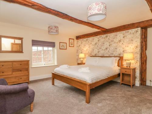 a bedroom with a large bed and a chair at Copmanthorpe Hall in York
