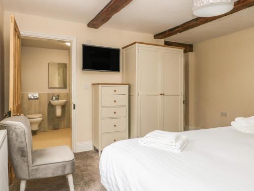 a bedroom with a bed and a chair and a television at Copmanthorpe Hall in York