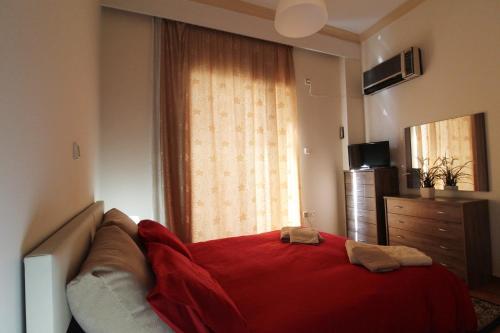 アテネにあるSea and City Apartmentのベッドルーム1室(赤いベッド1台、窓付)
