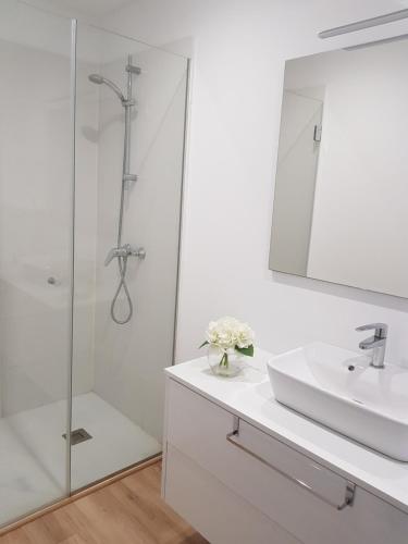 y baño blanco con lavabo y ducha. en Luxury suites, en Porto Cristo