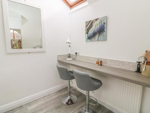 a bathroom with a counter and a sink and a chair at The Bothy in Sedbergh