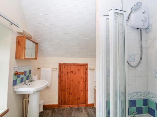a bathroom with a sink and a shower at Y Bwthyn in Pwllheli