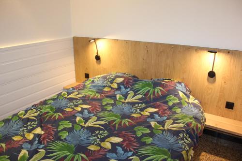 ステラ・プラージュにあるLes Goelandsのベッドルーム1室(カラフルな毛布付きのベッド1台付)