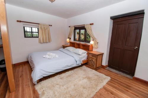 a small bedroom with a bed and a window at Hosteria Papagayo Cotopaxi in Machachi