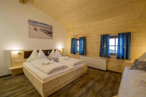 a bedroom with two beds in a wooden room at Kummererhof in Itter