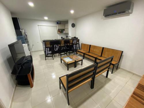 Sala de estar con bancos y mesa en Nueve Uno Hostel en Riohacha