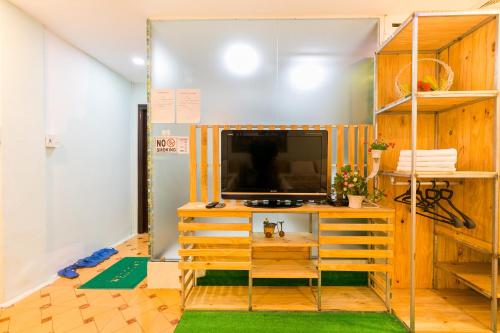 a living room with a tv on a wooden stand at Ben Thanh Dorm in Ho Chi Minh City