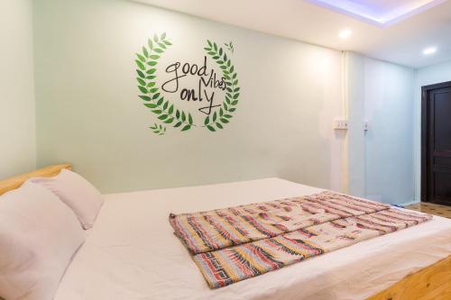 a bedroom with a bed with a green sign on the wall at Ben Thanh Dorm in Ho Chi Minh City