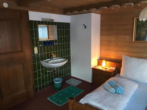 a bathroom with a bed and a sink in a room at Mitterhaidgut in Hollersbach im Pinzgau