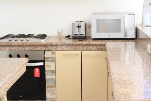 a kitchen with a counter top with a microwave at The Heights in Montañita in Montañita