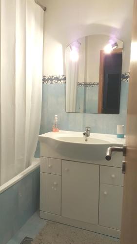 a bathroom with a white sink and a mirror at Atlantic Palm Garden Residence in Caniço