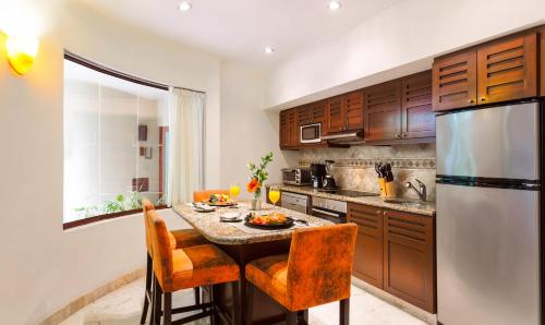 a kitchen with a table and a refrigerator at Maya Villa Condo Hotel and Beachclub in Playa del Carmen