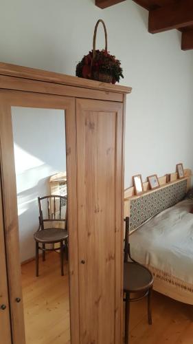 a bedroom with a wooden cabinet and a bed at Bakonyi Vadász Háza in Bakonykúti