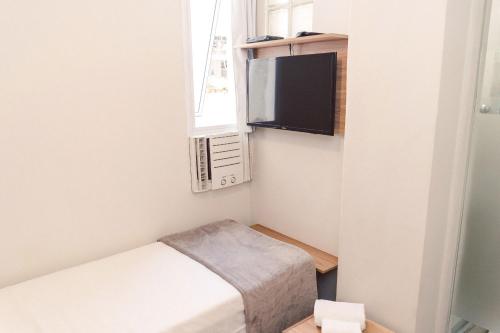a small room with a bed and a tv at CLH Suites Domingos Ferreira in Rio de Janeiro