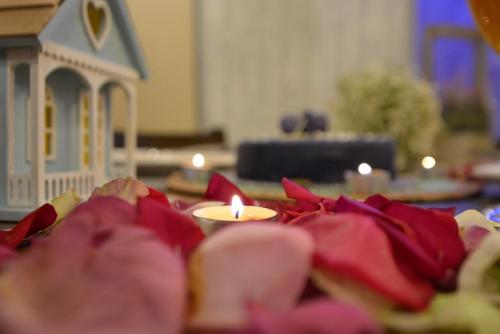 a table with a candle and red napkins and a toy house at Arto Aparthotel in Riyadh