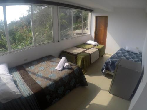 a bedroom with two beds and a window at The Heights in Montañita in Montañita