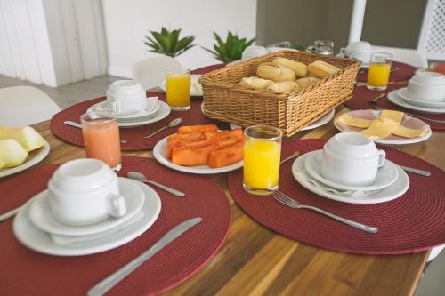 a table with plates of food and a basket of bread at CLH Suites Domingos Ferreira in Rio de Janeiro