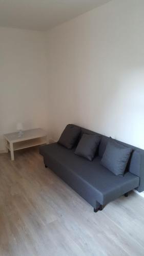a blue couch in a room with a table at Central Yellow Apartment in Brussels