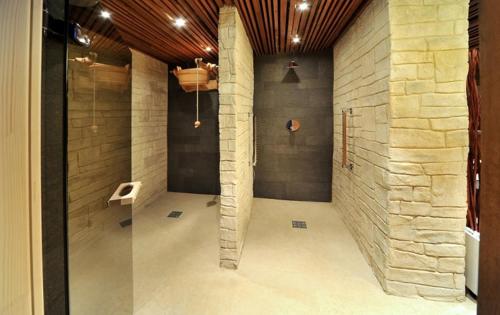 a room with a stone wall and a glass door at Via Jasna Apartment PL in Liptovský Mikuláš