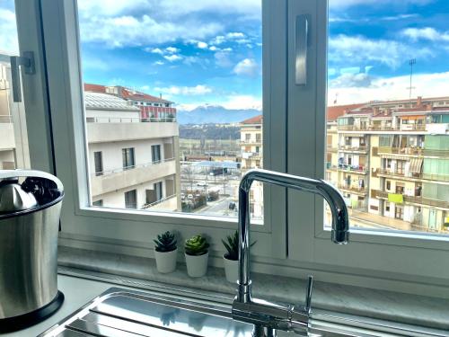 a kitchen sink with a view of a city from a window at A Cuneo in Terrazza in Cuneo
