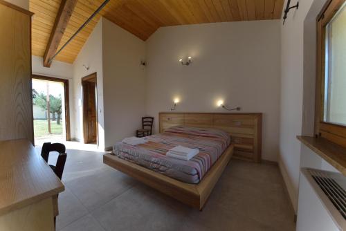 a bedroom with a bed in a room with a window at Casale Dei Mattonari in Giano dellʼUmbria