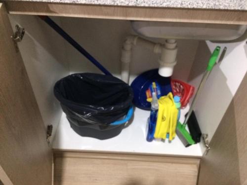 a shelf under a sink with office supplies on it at Apart Hotel R&P Depto B in Puerto Varas