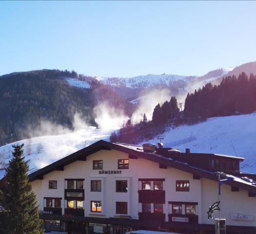 a building on a ski slope with mountains in the background at Appartementhaus Römerhof Superior in Bad Kleinkirchheim