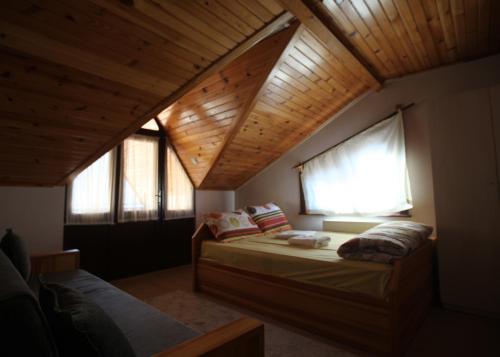 a bedroom with two beds and a wooden ceiling at Mekan Ilica Apart Otel in Karacasu
