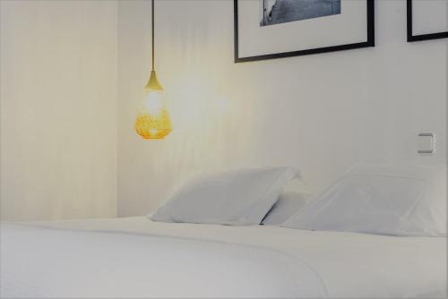 a bedroom with a white bed and a lamp at Comercial Azores Boutique in Ponta Delgada