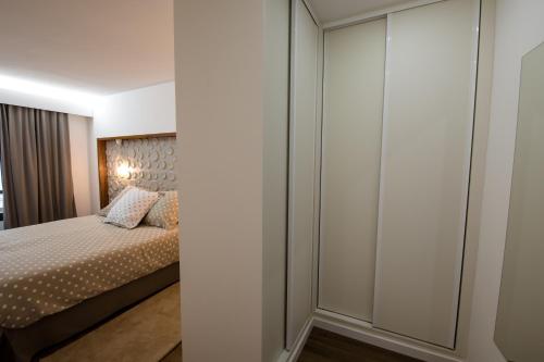 a bedroom with a bed and a closet at Slope House in Lagoa