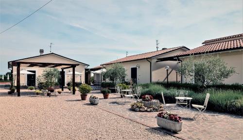 a patio with tables and chairs and a building at Residence Terra Dei Santi Country House in Spello