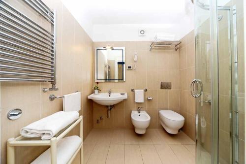 a bathroom with a sink, toilet and bathtub at Hotel Villa Svizzera Terme in Ischia