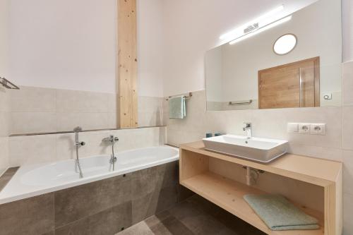 a bathroom with a sink and a bath tub at Appartement Fritz inkl Summer Card in Umhausen