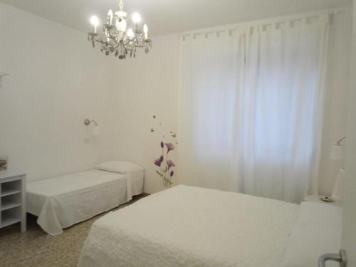 a white bedroom with two beds and a chandelier at B&Belvedere, affittacamere in San Benedetto del Tronto