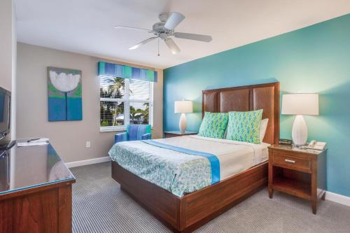 a bedroom with a bed with a blue wall at Gull Wing Beach in Fort Myers Beach