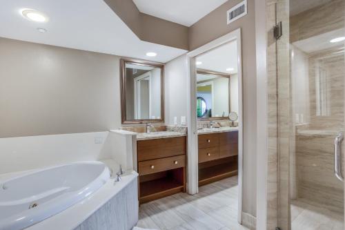 a bathroom with a tub and two sinks and a shower at Gull Wing Beach in Fort Myers Beach