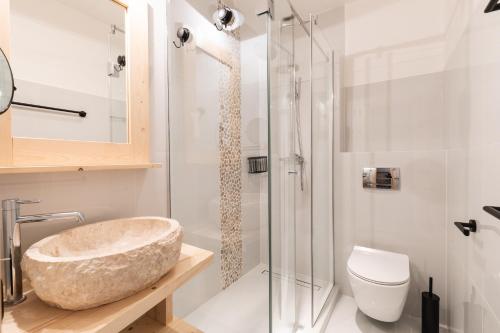 een badkamer met een stenen wastafel en een douche bij Apartamenty Zobacz Giewont Zakopane in Kościelisko