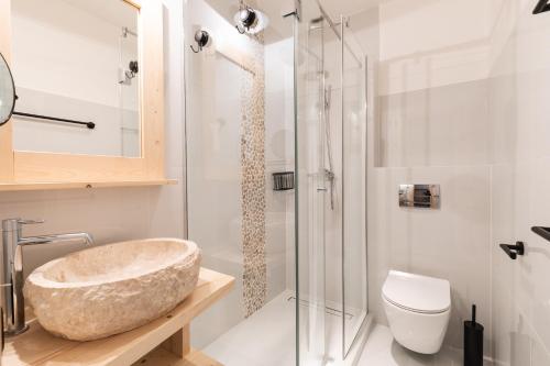 a bathroom with a stone sink and a shower at Apartamenty Zobacz Giewont Zakopane in Kościelisko