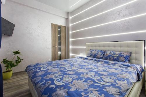 a bedroom with a bed with a blue and white comforter at New luxury Apartment in the Center on Konstitution Square in Kharkiv