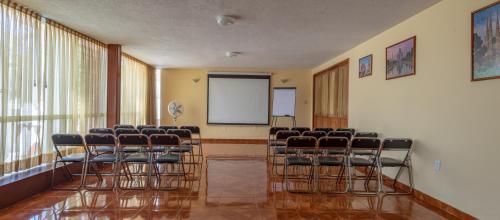 una sala de conferencias con sillas y una pantalla blanca en Casa Shalom Puebla, en Puebla