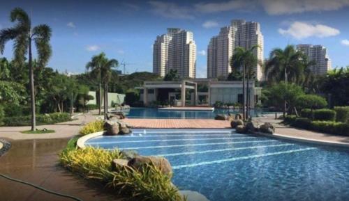 a swimming pool in a resort with tall buildings at Studio Condominium - Short and Long Term Staycation in Manila