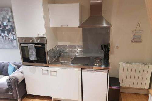 une petite cuisine avec un évier et un micro-ondes dans l'établissement Au Mont Pour Deux, à Pontorson