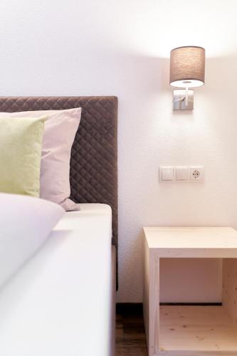 a bedroom with a bed and a nightstand with a lamp at Appartement Fritz inkl Summer Card in Umhausen