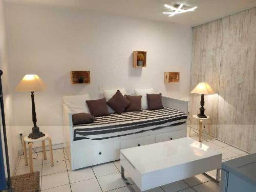 - un lit dans une chambre avec deux lampes et un canapé dans l'établissement STUDIO TOUT A PIEDS, à Sanary-sur-Mer