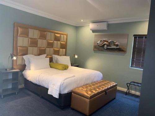 a bedroom with a large bed with a car on the wall at La Fiato Luxury Lodge in Dalmada AH