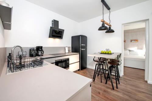 uma cozinha com balcões brancos e um frigorífico preto em Apartment Margita em Rovinj