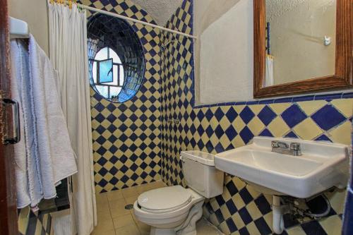 a bathroom with a sink and a toilet and a mirror at Hotel Sautto in San Miguel de Allende