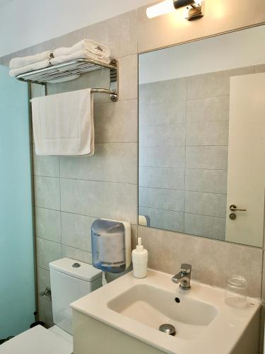 a bathroom with a sink and a toilet and a mirror at The Blue Corner Apartments in Puerto de la Cruz